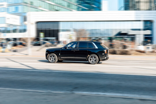 Rolls-Royce Cullinan car moving on the street. Compliance with speed limits on road concept. Dynamic exterior image