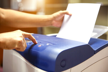 Technician hand press button and load paper in tray to using photocopier for scanning fax or...