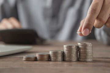Businessman choose pile of coins stacked in a graph for money saving planning ideas.
