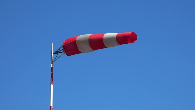 Windsock or wind vane against the blue sky indicates the strength and direction of the wind