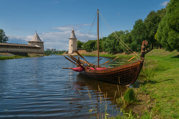 View of the Slavic and Old Russian sailing and rowing sea and river vessel rook against the background of the Pskov Kremlin (krom) on a sunny summer day, Pskov, Russia