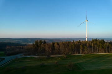 Fototapeta premium A wind turbine in the forest. Alternative energy to expensive gas and oil. Germany, Winterbach.