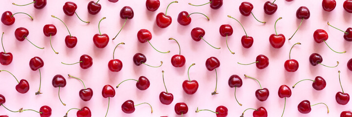 Banner with pattern of red sweet cherry berries on pink background. Flat lay Top view