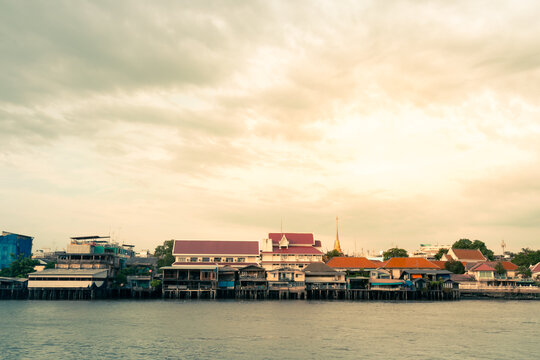 View from a passenger ship on a tropical landscape background of a community in Bangkok adjacent to Thailand's Chao Phraya River.