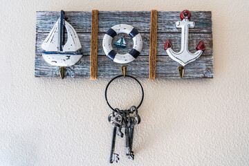 Original hanger on the wall decorated with images of a yacht, a life buoy and an anchor inside a...