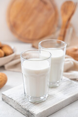 Two glasses of potato milk with raw potatoes on a white background. Vegetarian milk.