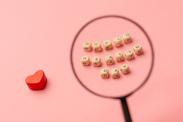 World Health Day, medical and healthcare. Red heart and close-up text World Health Day under a magnifying glass on pink background