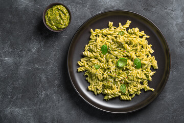 Pasta with pesto sauce, fresh basil leaves and sesame seeds. Top view, copy space.