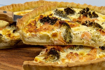 cut broccoli salmon pie on a wooden board