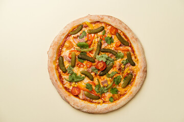 Pizza with juicy bacon, cherry tomatoes, corn, cilantro, pickled cucumbers, Pilati sauce, gouda cheese and mozzarella. Beige background. Top view. Copy space