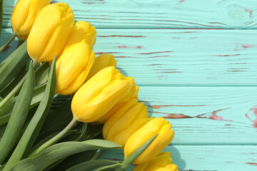 yellow tulips on a wooden table
