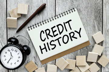 Credit History. text on an open notebook near the table clock and cubes