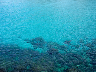 Fototapeta na wymiar Turquoise sea background with copy space. Clean and transparent water in the Mediterranean sea. Rocks under the water. Majorca, Balearic Islands, Spain