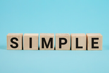 SIMPLE word from wooden blocks with letters, to make something easy, keep it simple concept, blue...