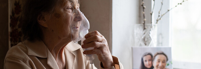very old woman and nebulizer. Woman making inhalation