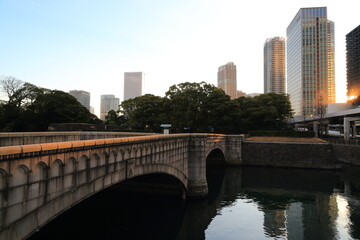 Fototapeta premium 庭園に続く石橋と高層ビル群夕景