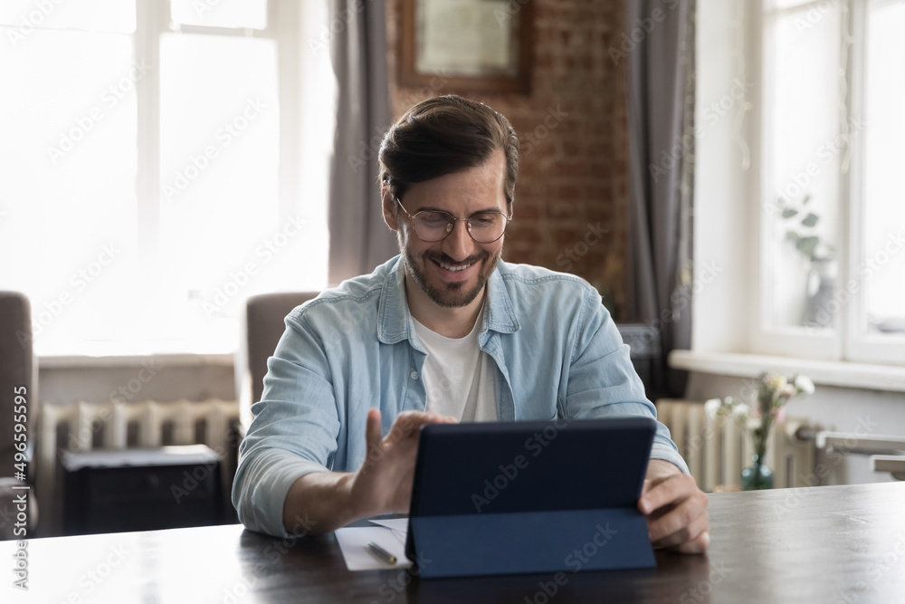 Wall mural happy millennial businessman in casual using tablet computer, working in stylish loft office, touchi