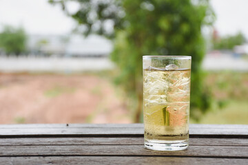 Clear glass with ice on a wooden table