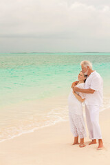 Loving Caucasian couple in white clothes on a Caribbean beach