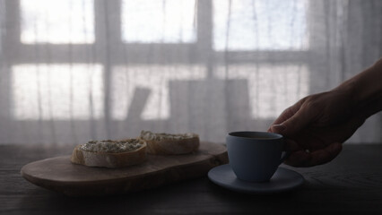 man hand take cup of espresso and ciabatta with cream cheese