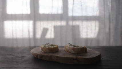 cream cheese on ciabatta to make sandwich on wood board
