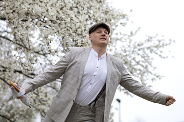 Beautiful smiling man on the background of white flowering magnolia