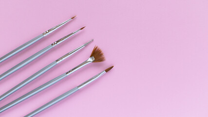 Nail service banner. Brushes for manicure on a pink background. Layout of manicure accessories. Pink background. Women's set.