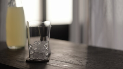 add crushed ice in tumbler glass with crushed ice on wood table