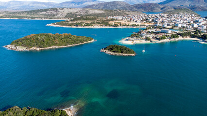 Obraz premium Aerial drone view of the beautiful seaside coast on a sunny day. Marvelous blue colors. Holidays and relaxing mood. Islands and boats. Amazing beaches to mediate and cure the soul. Vibrant colors. 