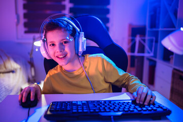 Little boy playing video game in the dark room