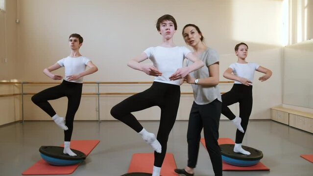 Ballet Dancing Class: Teacher Choreographer explains the Exercise of Ballet Gymnastics to Boys Students. Dancing Classes in Sports School. Support and Help from Instructor