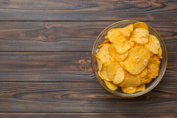 Potato chips on bowl isolated on colored background. Delicious crispy potato chips in bowl. Space for text. Top view