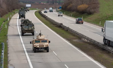 Keuken spatwand met foto Army military convoy passes  in Czech Republic. Wheeled armored vehicles drive on highway . © patrikslezak