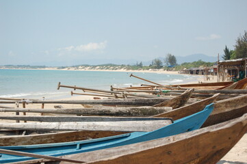 Fototapeta na wymiar Small wooden fishing boats with paddles on a sandy beach in Vietnam.