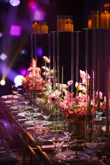Banquet table decorations with anemone flowers and colored light in a blue light party. Seats at the table.