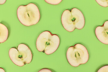 Top view of apple slices on green background