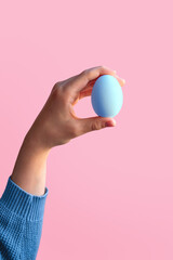 Hand holding an blue painted Easter egg. Easter concept.