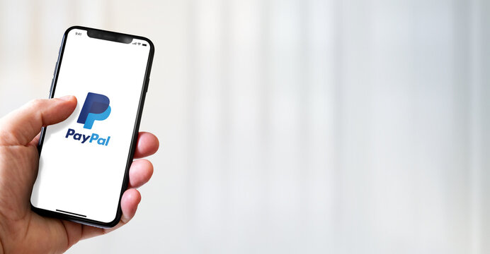 Hand holding iphone smartphone with Paypal logo, Paris, France