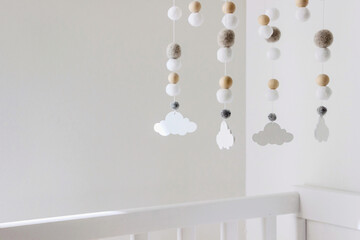 white crib with cute cloud mobile in nursery room	 - 496604775