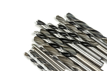 several different metal drills on a white background. close-up