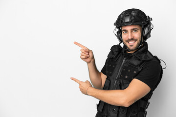 Young caucasian swat isolated on white background pointing finger to the side and presenting a product