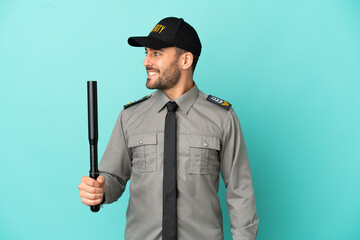 Young security man isolated on blue background looking side