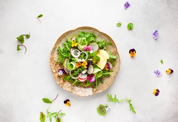 Tafelkleed Delicious summer salad with edible flowers, vegetables, fruit, microgreens and cheese. Clean and healthy eating concept. Top view. © Svetlana Kolpakova