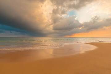 Magnificent sandy ocean beach under gorgeous sunset sky with clouds. Beautiful seascape.