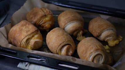 Homemade pastry puff buns with cheese on a baking sheet close-up