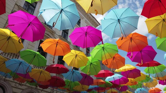 multicolored umbrella hanging on the street on a sunny day