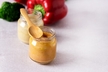 Glass Jars with Natural Baby Food on the Light Gray Background Vegetable Puree with Broccoli and Red Pepper Copy space