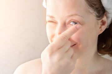 woman putting soft hydrogel contact lenses on her eyes