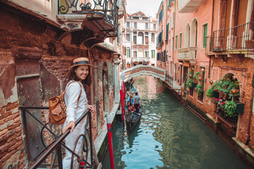 Fototapeta na wymiar portrait of smiling woman looking at canal with gandola