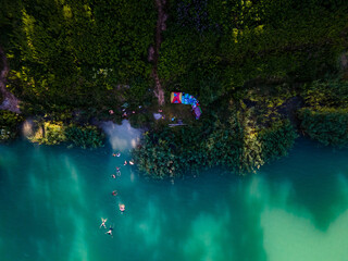 Fototapeta premium overhead view of leak beach blue water. people having fun swimming sunbathing